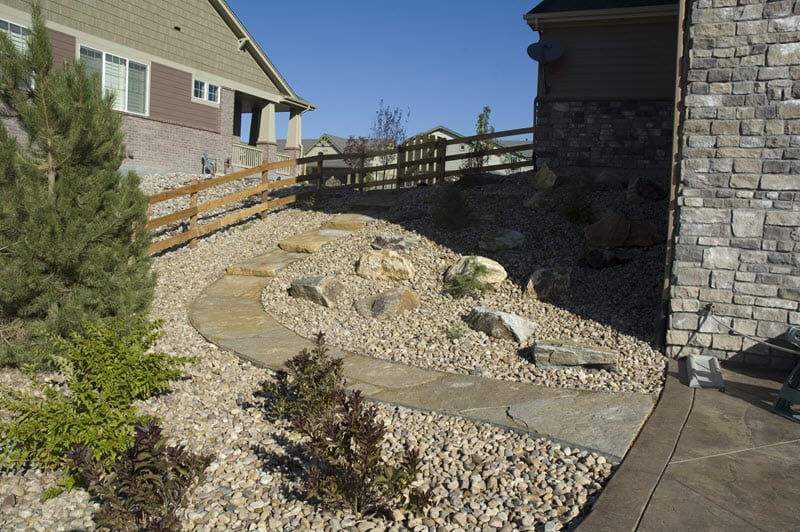 A graded slope with a flagstone path and landscaping rocks